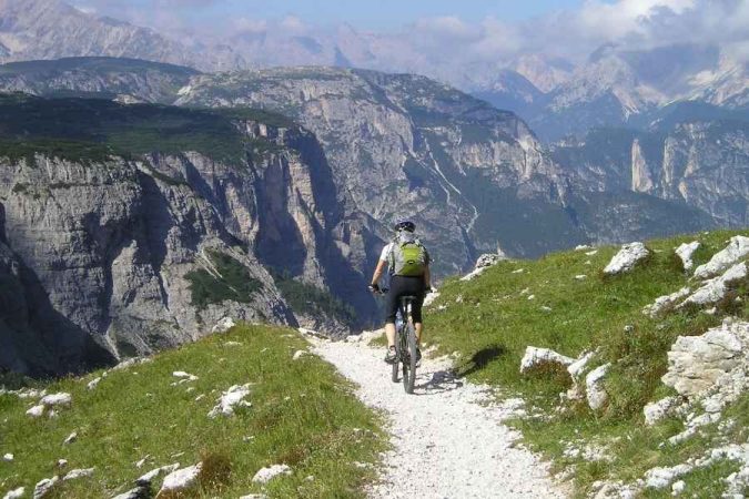 Mountain biker with essential bicycle touring gear exploring alpine trail
