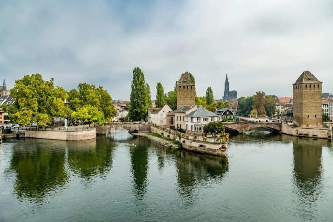 Historic medieval towers and bridge reflected in calm river water in Eastern Europe